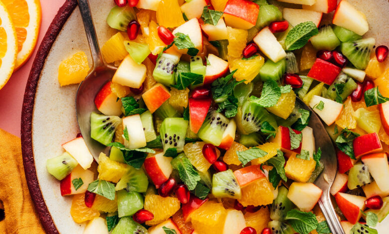 Serving spoons resting in a bowl of our easy winter fruit salad recipe