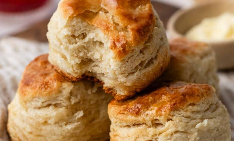 3 homemade biscuits in a pile on striped linen.