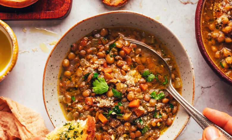 Bowls of Italian lentil soup with slices of garlic bread