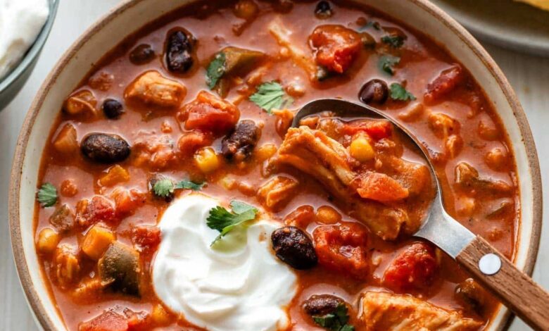 bowl of slow cooker chicken chili with sour cream on top.