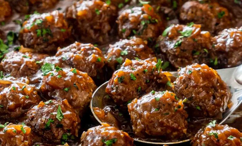 salisbury steak meatballs with gravy in a skillet garnished with parsley.