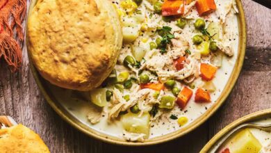 chicken soup with vegetables and biscuit in bowl on table